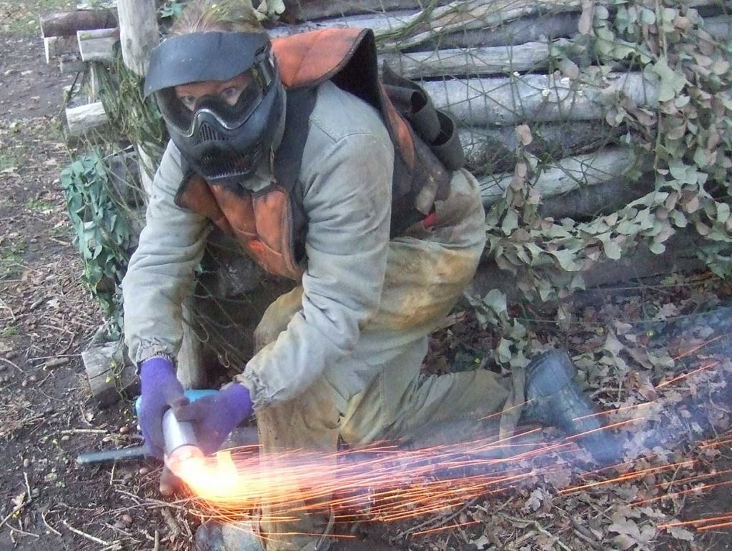 Woman lighting a smoke grenade behind a barricade before throwing it.