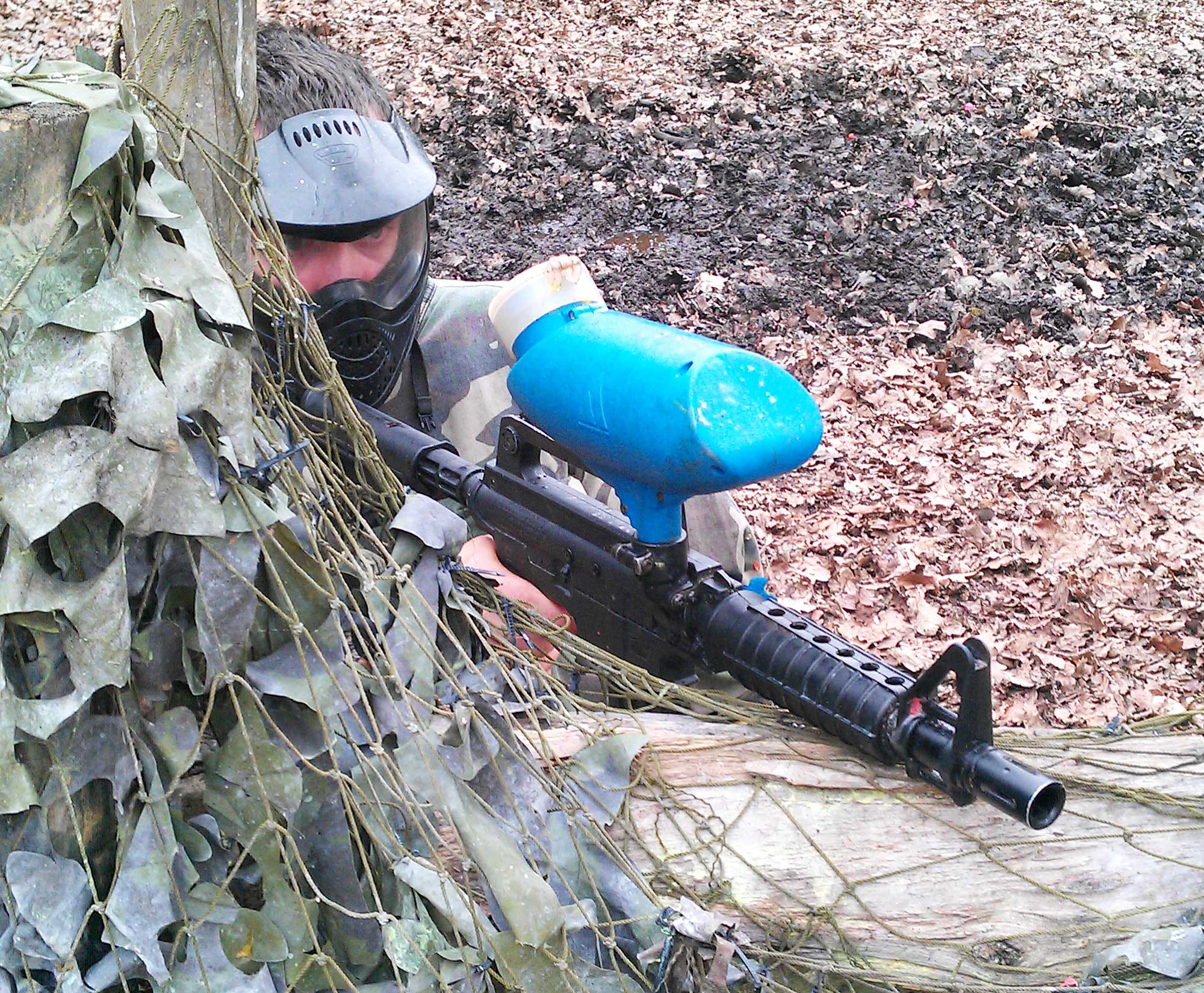 player from the blue team firing a bravo one paintball upgrade marker
