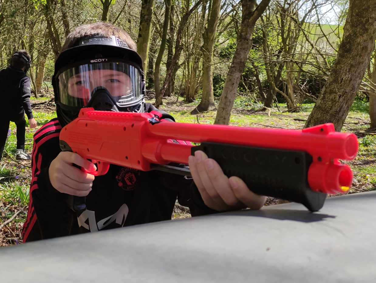 child aiming a z200 paintball shotgun over a bunker